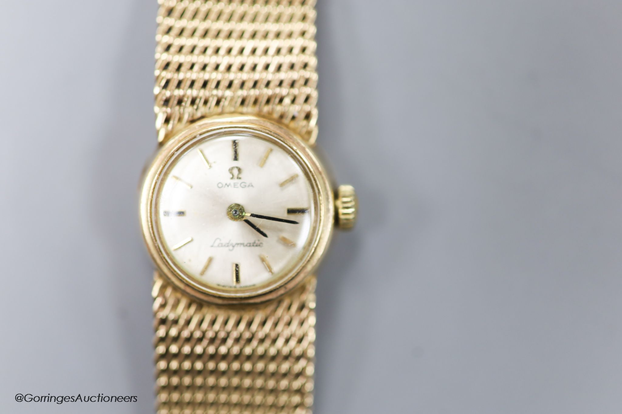 A lady's 9ct gold Omega Ladymatic wrist watch on integral 9ct gold Omega bracelet